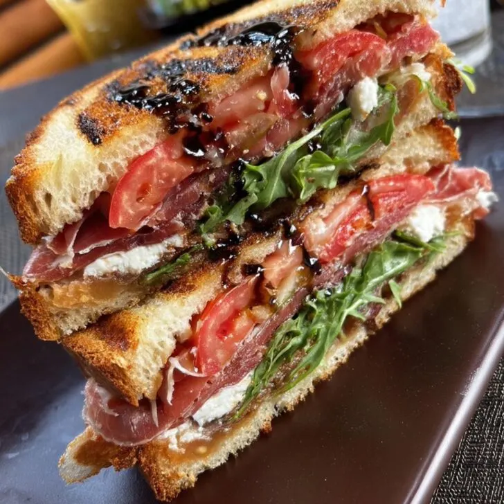 Smoked dry cured prosciutto, goat cheese, baby aragula, tomato and balsamic glaze panini